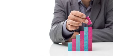Businessman building a staircase using toy wood blocks, business success and development concept