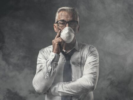 Corporate businessman wearing a protective mask for air pollution, business and environmental care conceptの写真素材