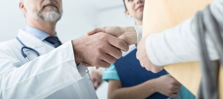 Doctor and patient shaking hands after a consultation at the hospital and medical staff, medical exams and healthcare conceptの写真素材