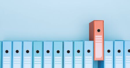 Organized archive with ring binders in a row, one is red: archive, database and search concept