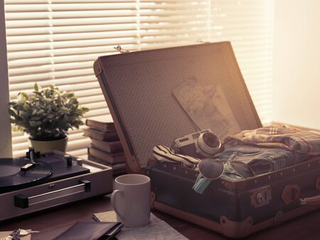 Traveler packing his luggage before leaving for a vacation: open vintage suitcase with clothes, camera and vintage record player, travel and retro revival conceptの写真素材