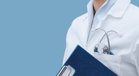 Professional female doctor holding a clipboard and posing, healthcare professionals concept