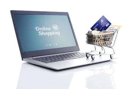 Shopping cart full of money and laptop: e-commerce, online banking and e-payments concept, white backgroundの写真素材