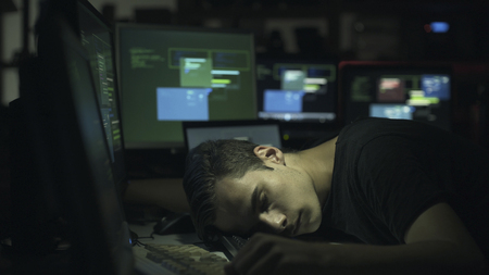 Hacker and computer developer sleeping on the desk late at night, hacking and overwork conceptの写真素材