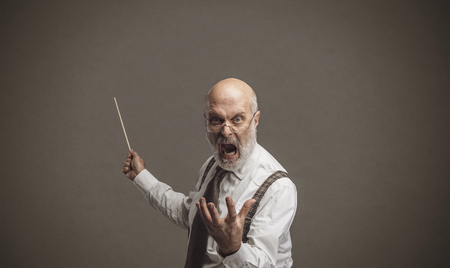 Senior authoritarian professor yelling and pointing at the blackboard with a stick: traditional...