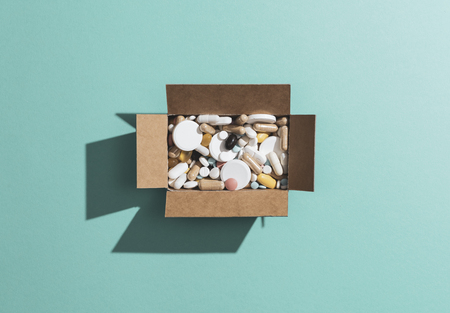 Delivery box filled with assorted prescription medicines and drugs: self medication, addiction and drug abuse conceptの写真素材