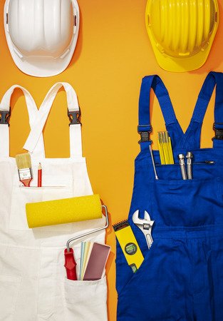 Repairman and painter work uniforms with tools and safety helmets, DIY and home renovation conceptの写真素材