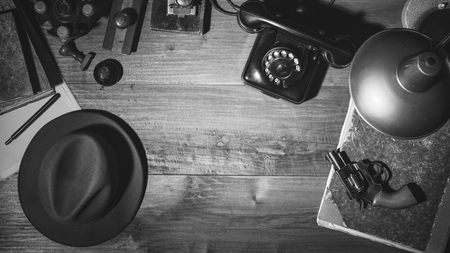 Noir 1950s style detective vintage desktop with revolver, fedora hat and telephone, flat layの写真素材