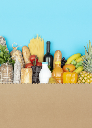 Big shopping bag with assorted fresh grocery products: vegetables, fruit, drinks and cured meatの写真素材