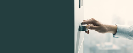 Professional secretary working and searching files in the archive, she is opening a filing cabinet's drawerの写真素材