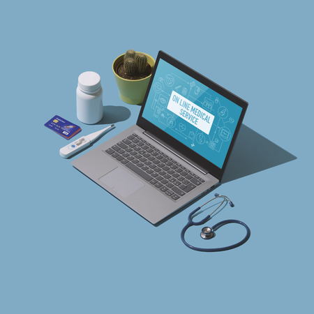 Online healthcare service and telemedicine: laptop, credit cards and medical equipmentの写真素材