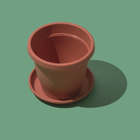 Plastic empty flower pot on green background, gardening and hobby conceptの写真素材