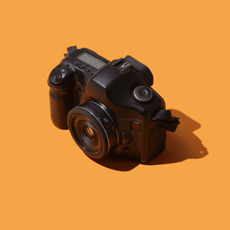 Professional digital reflex camera on yellow background, photography conceptの写真素材
