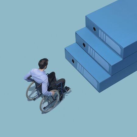 Man in wheelchair stopping in front of a staircase made of folders, accessibility conceptの写真素材