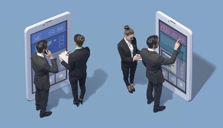 Corporate business people working together with big touch screen smartphones and using financial apps, technology and teamwork conceptの写真素材