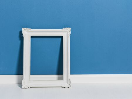 Elegant white empty frame leaning on the floor, blank copy space, art and decoration concept