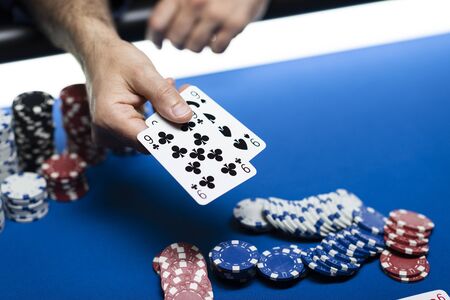 Man playing Texas Hold 'em poker at Casino, he is holding two cards