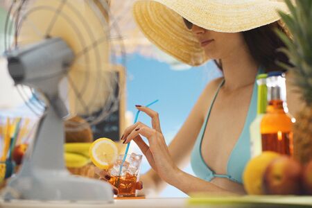 Attractive young woman relaxing at the beach, she is having a delicious cocktail at the bar kioskの写真素材