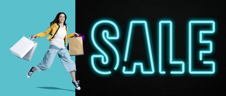 Promotional sale banner with smiling cheerful girl running and holding bags
