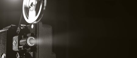 Vintage old fashioned projector in a dark room projecting a film, cinematography concept