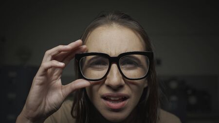Woman wearing glasses and staring at the computer screen, she has eyesight problemsの写真素材