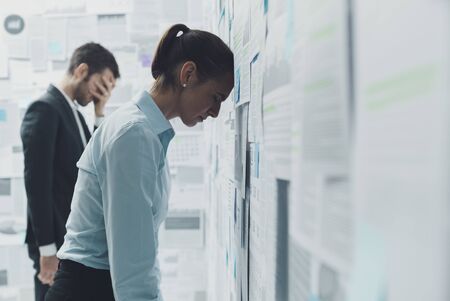 Exhausted stressed business team overloaded with financial reports and problems