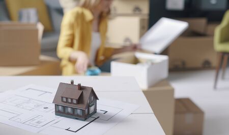 People moving in a new house, project and model home in the foreground, home renovation and relocation conceptの写真素材
