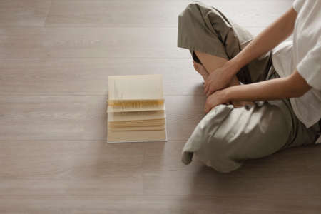 Woman sitting on the floor and reading a book, leisure and relaxation conceptの写真素材