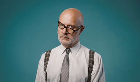 Frustrated serious businessman with crooked glasses, he is staring at cameraの写真素材