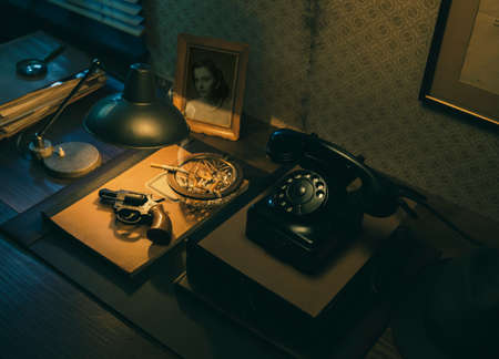 Film noir detective desktop with revolver, whiskey and ashtray, thriller and suspense conceptの写真素材