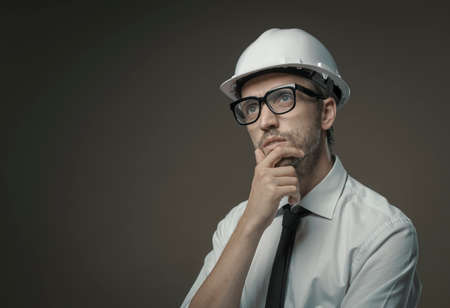 Construction engineer thinking with hand on chin: problem solving and planning conceptの写真素材