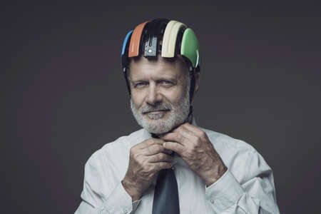 Senior businessman wearing a cycling helmet, safe business and protection conceptの写真素材