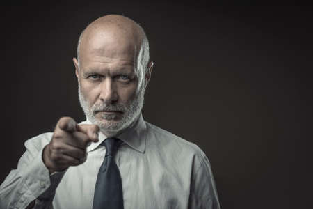 Corporate business executive pointing at camera, selection and recruitment conceptの写真素材