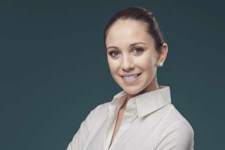 Happy young woman in white shirt, she is smiling at camera