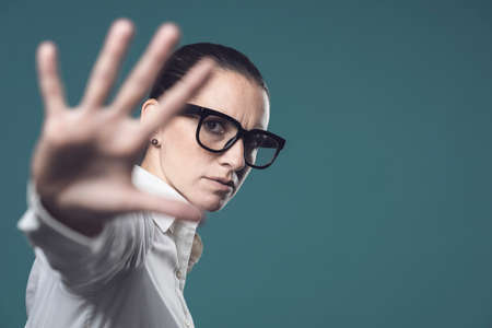Confident woman putting her hand forward and making a stop gestureの写真素材