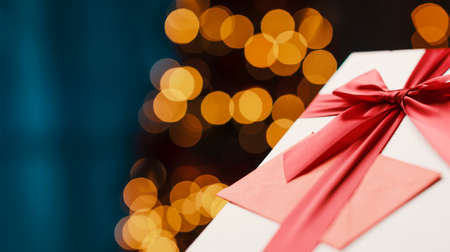 Beautiful Christmas gift with Christmas card and decorative lights, close upの写真素材