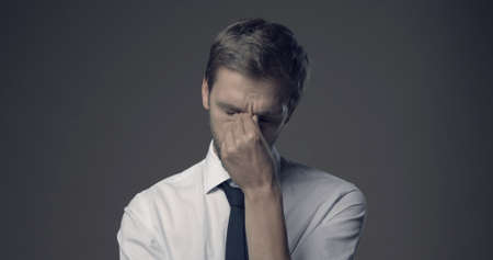 Stressed businessman with headache, he is feeling exhausted and sad