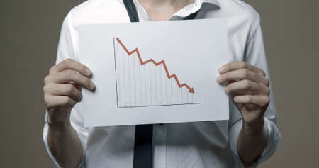 Businessman holding a negative financial chart, bankruptcy and financial crisis conceptの写真素材