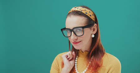 Attractive vintage style woman with glasses smiling at cameraの写真素材