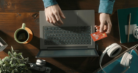 Businessman doing online shopping, he is connecting with his laptop and holding a credit card