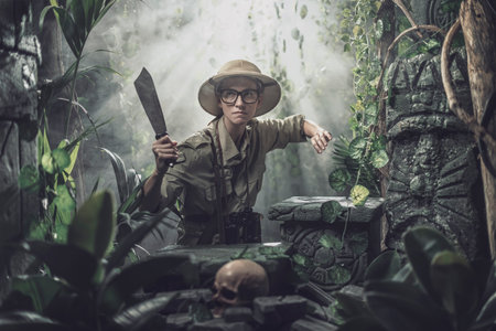 Vintage adventurer exploring the jungle and holding a machete, she finds ancient ruinsの写真素材