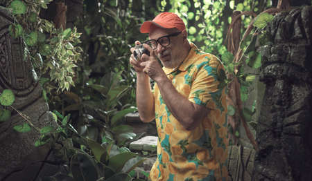 Funny tourist taking pictures of ancient ruins in the jungle