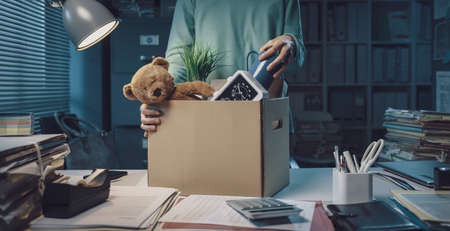 Woman packing her belongings in the office after being fired