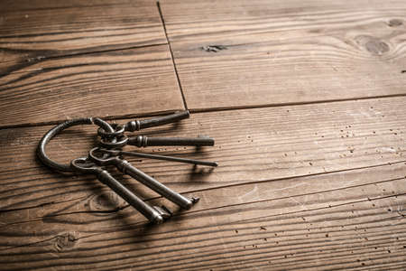 Ancient rusty keys on a wooden table and blank copy spaceの写真素材