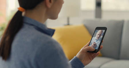 Woman having a video call with her doctor at home, telemedicine concept