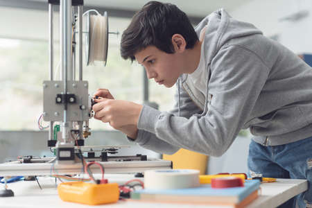 Smart young student learning 3D printing, he is checking the printer