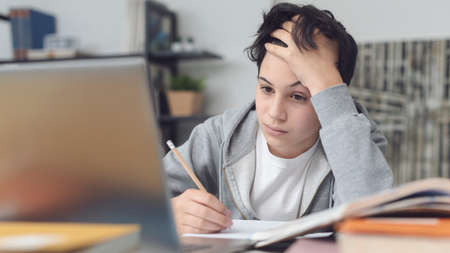Tired student taking online classes, he is confused and staring at the computer screen