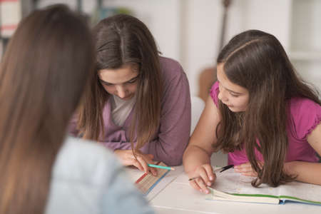 Happy students doing homework together, education and learning at home concept