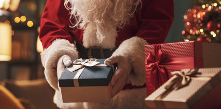 Santa Claus delivering Christmas gifts at home, holidays and celebrations conceptの写真素材