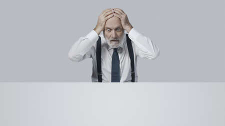 Stressed desperate businessman receiving bad news, he is in troubleの写真素材